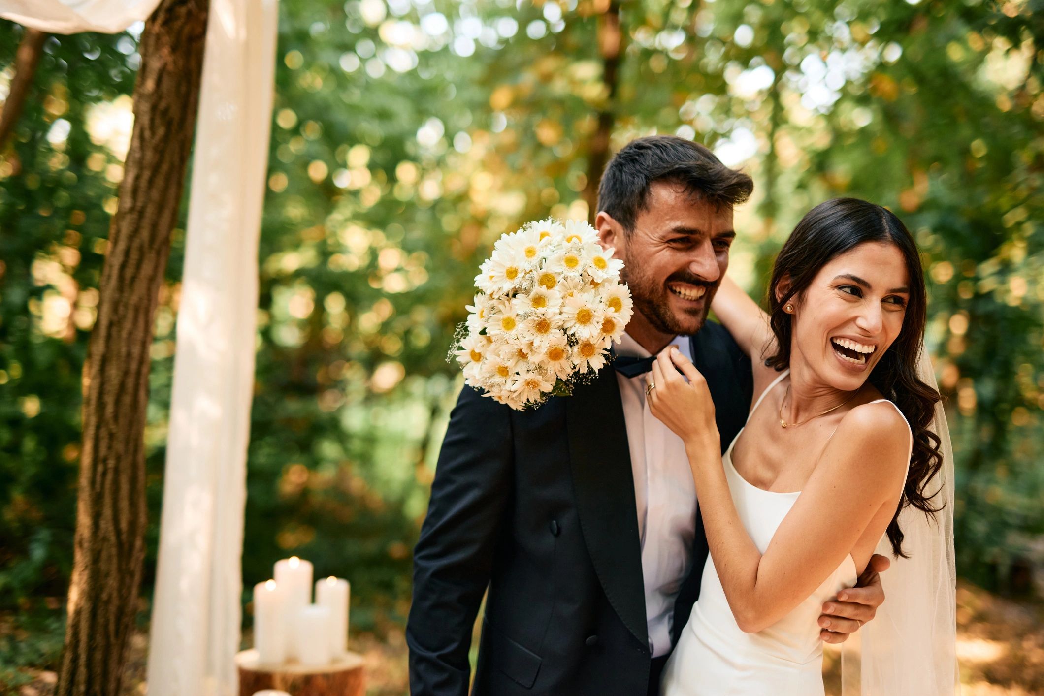 Newlyweds laughing during a woodland wedding ceremony